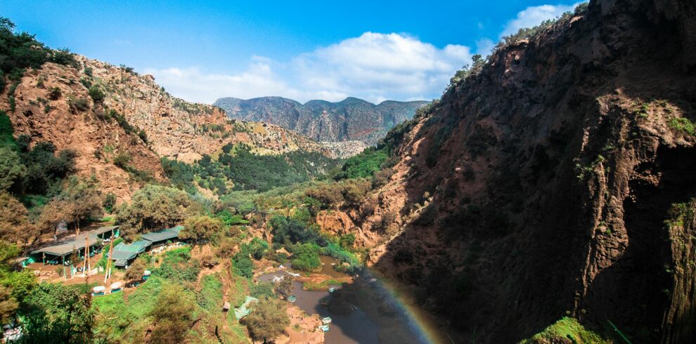 Beautiful canyon landscape with river and rainbow under clear blue sky, perfect for summer travel imagery.